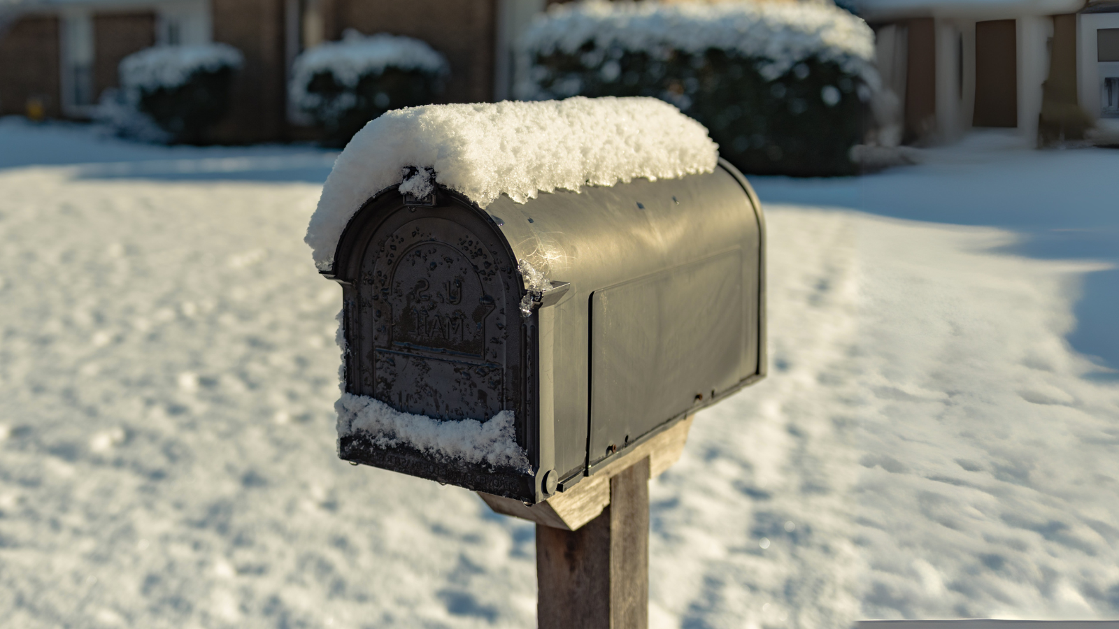 Mailbox in front of house with snow